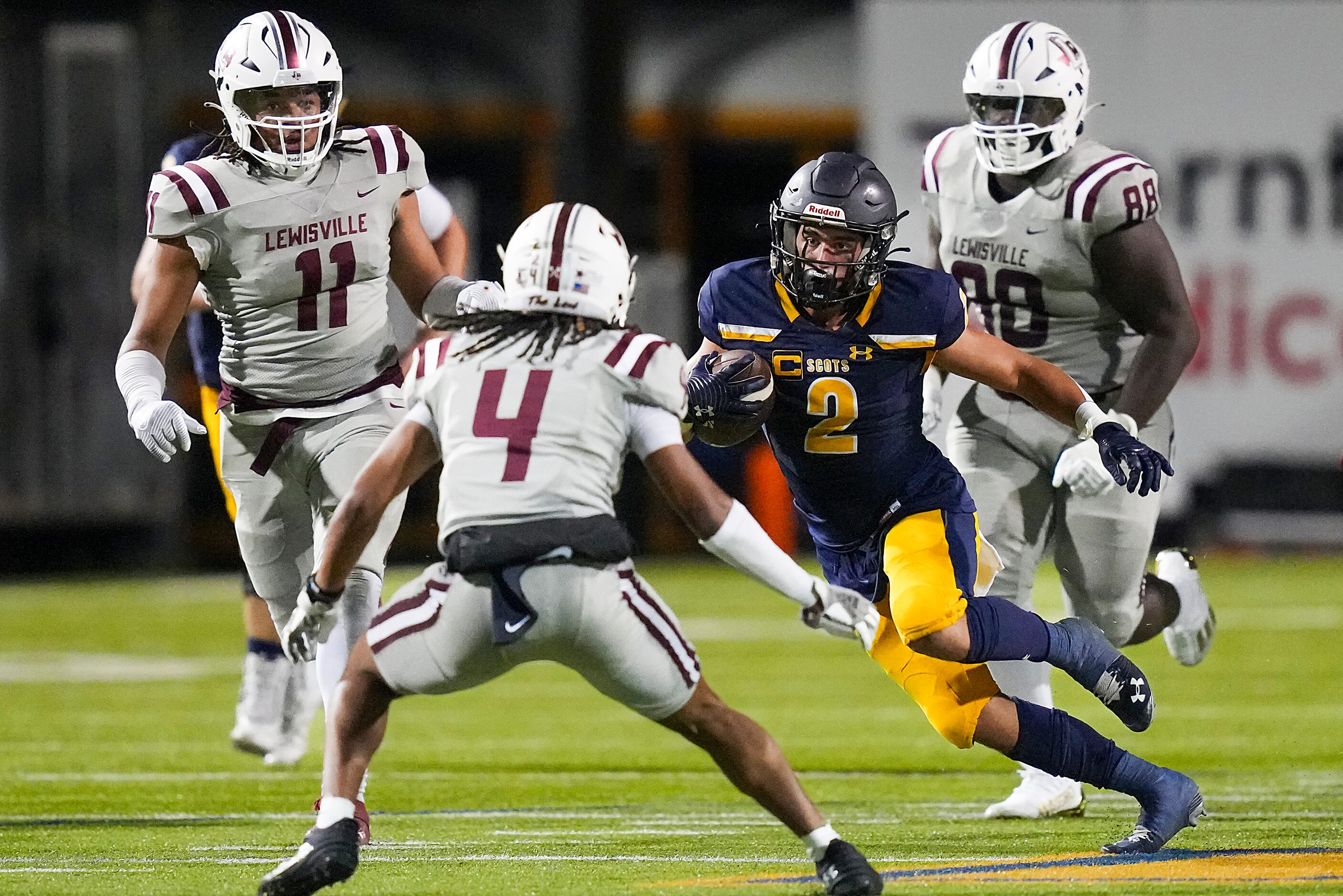 Highland Park running back Wilson Axley (2) runs between Lewisville defensive back D'angelo...