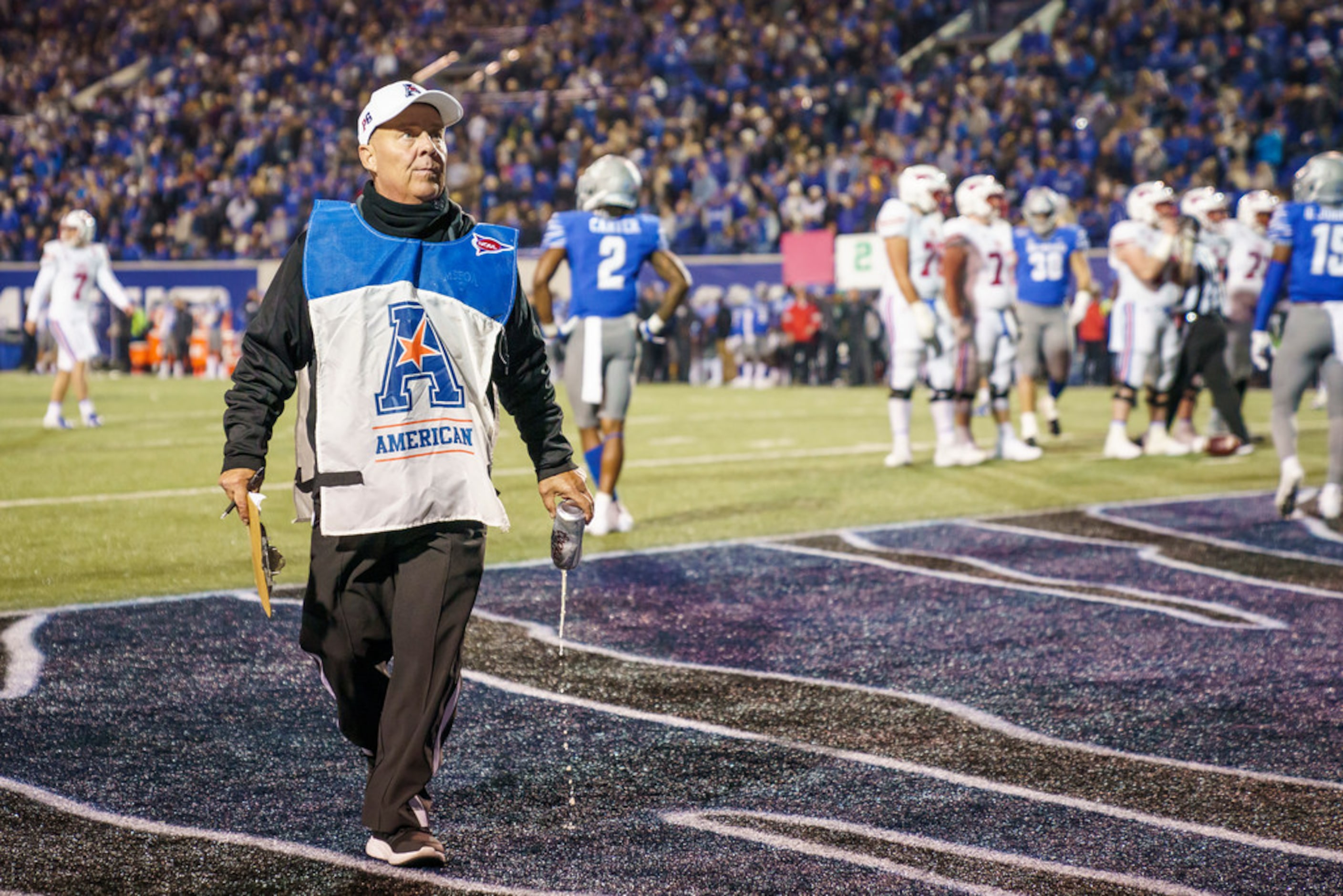 An official pours out a beer thrown on the field after a pass interference call went against...