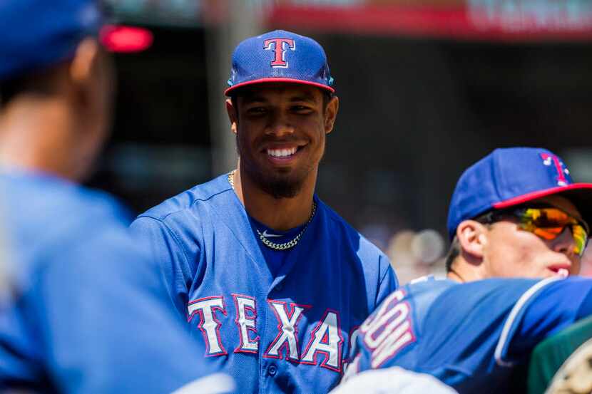 Texas Rangers outfielder Nick Williams (50) talks with teammates in the dugout during the...