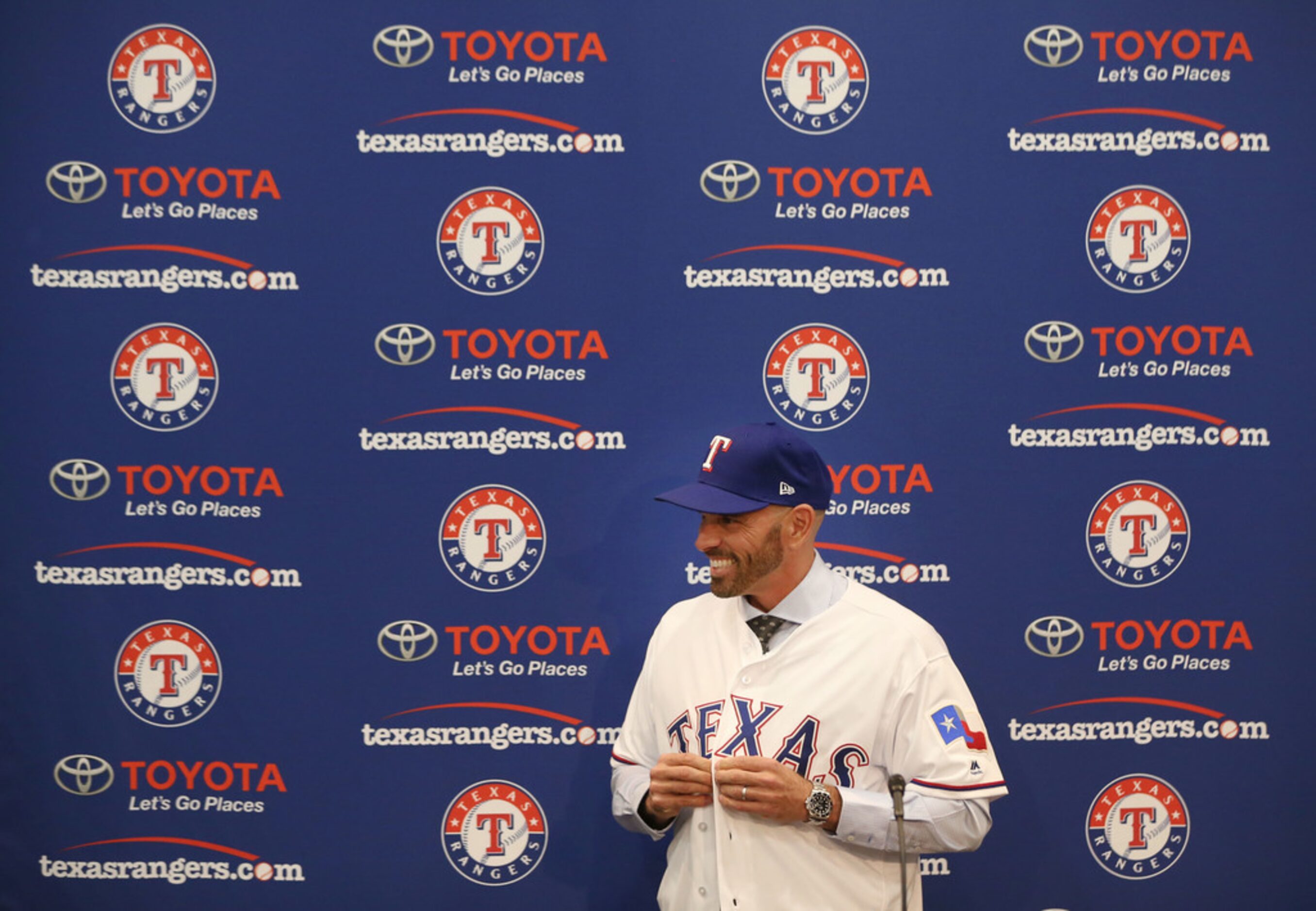 Texas Rangers' new manager Chris Woodward puts on a Texas Rangers jersey during a press...