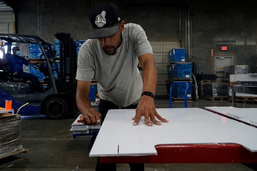 Fabricator Brandon Dodson prepares a sneeze guard at Regal Plastics in Irving.