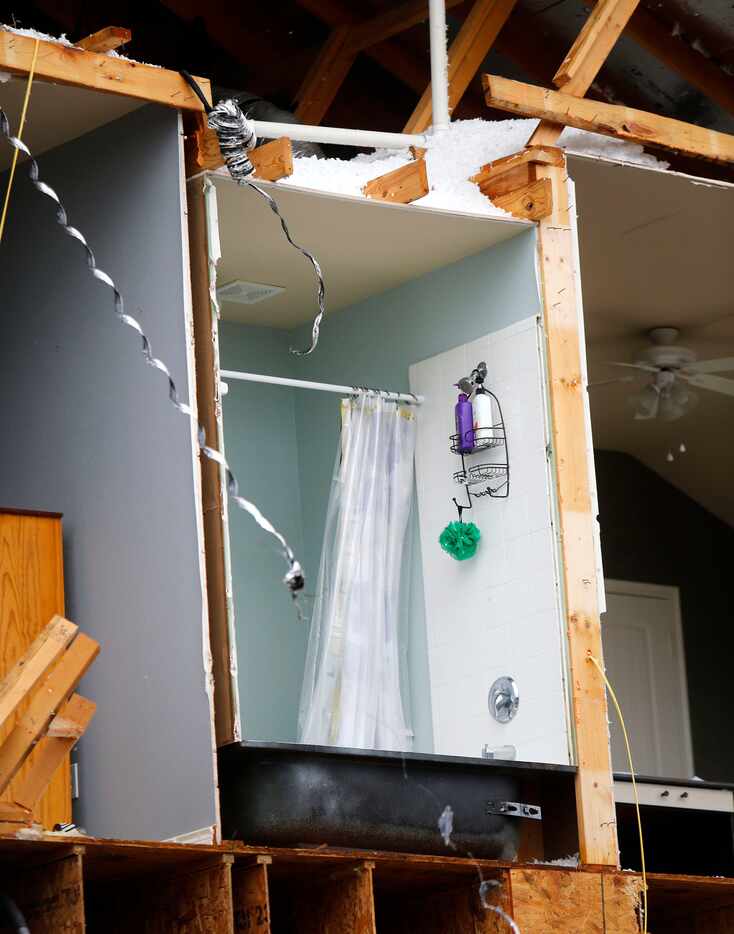 A shower curtain, loofah and soap remain intact in a damaged home along Tumbleweed Circle in...