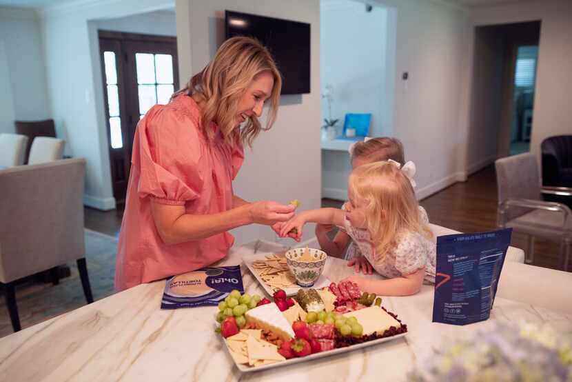 Lauren Schwalb, founder of Ohla! Foods, feeds a snack of ChipOhla! chips to her children...