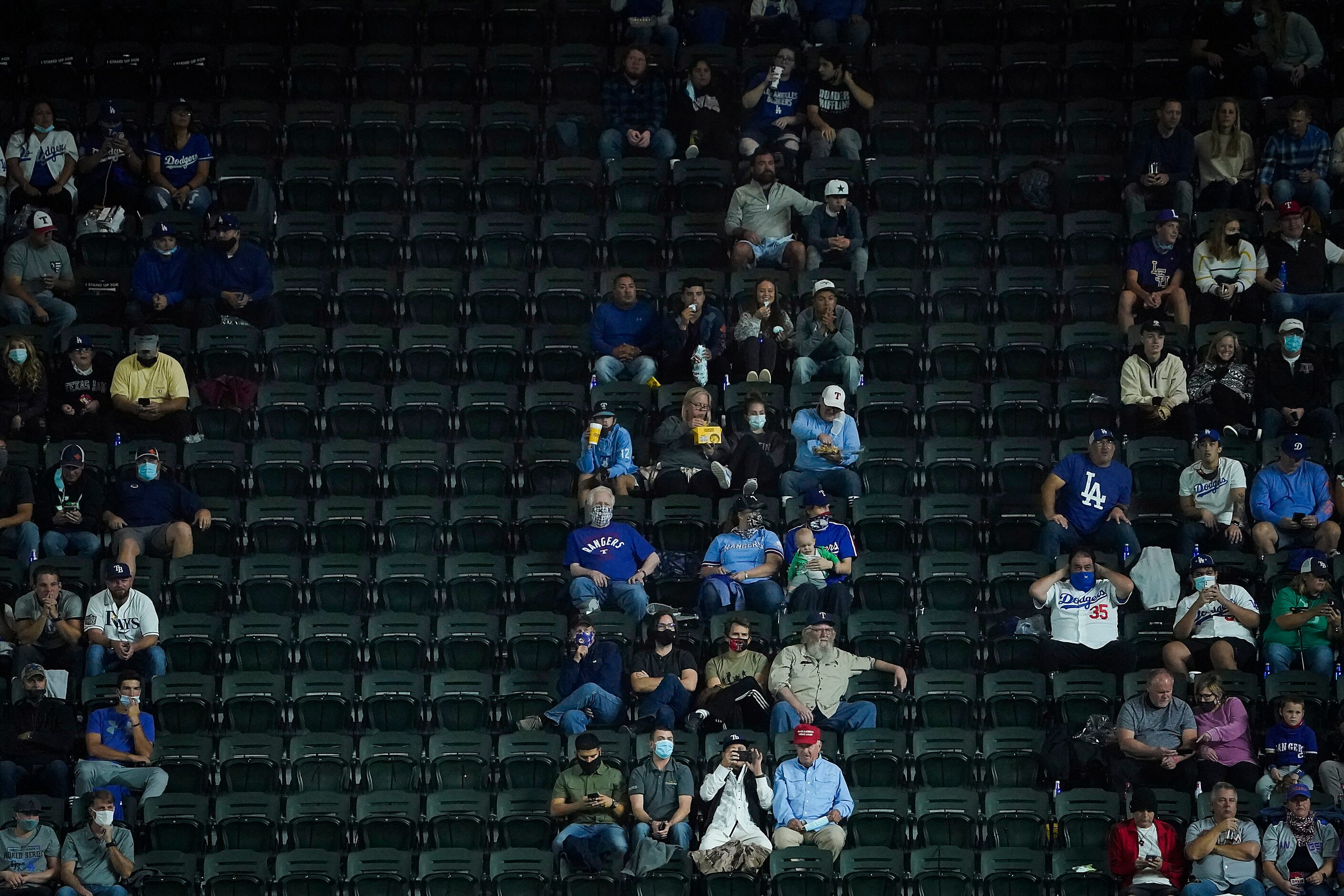 Socially distant fans in “pods” watch during the first inning in Game 3 of the World Series...