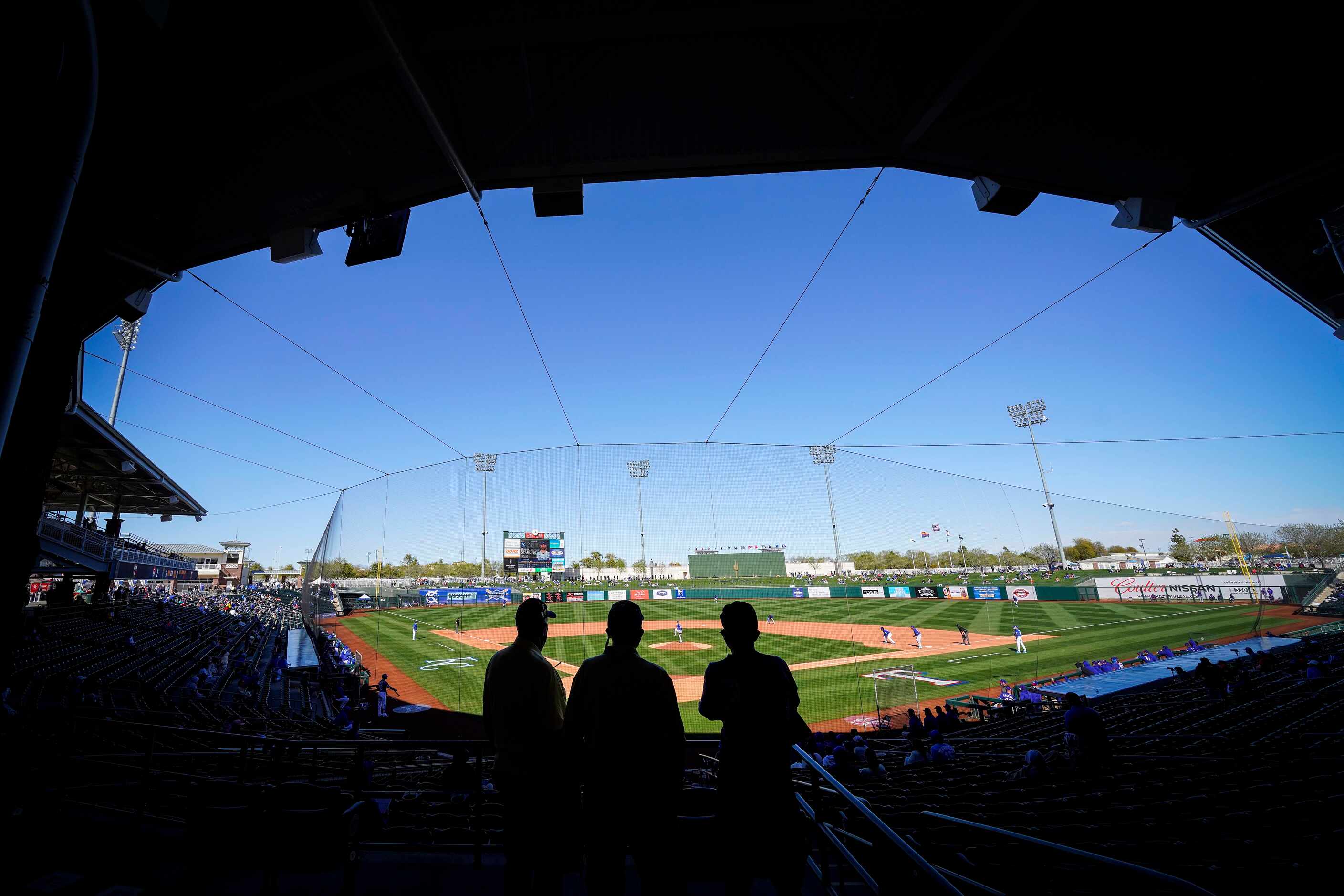 Fans watch from socially distant ‘pods’ during a spring training game between the Texas...