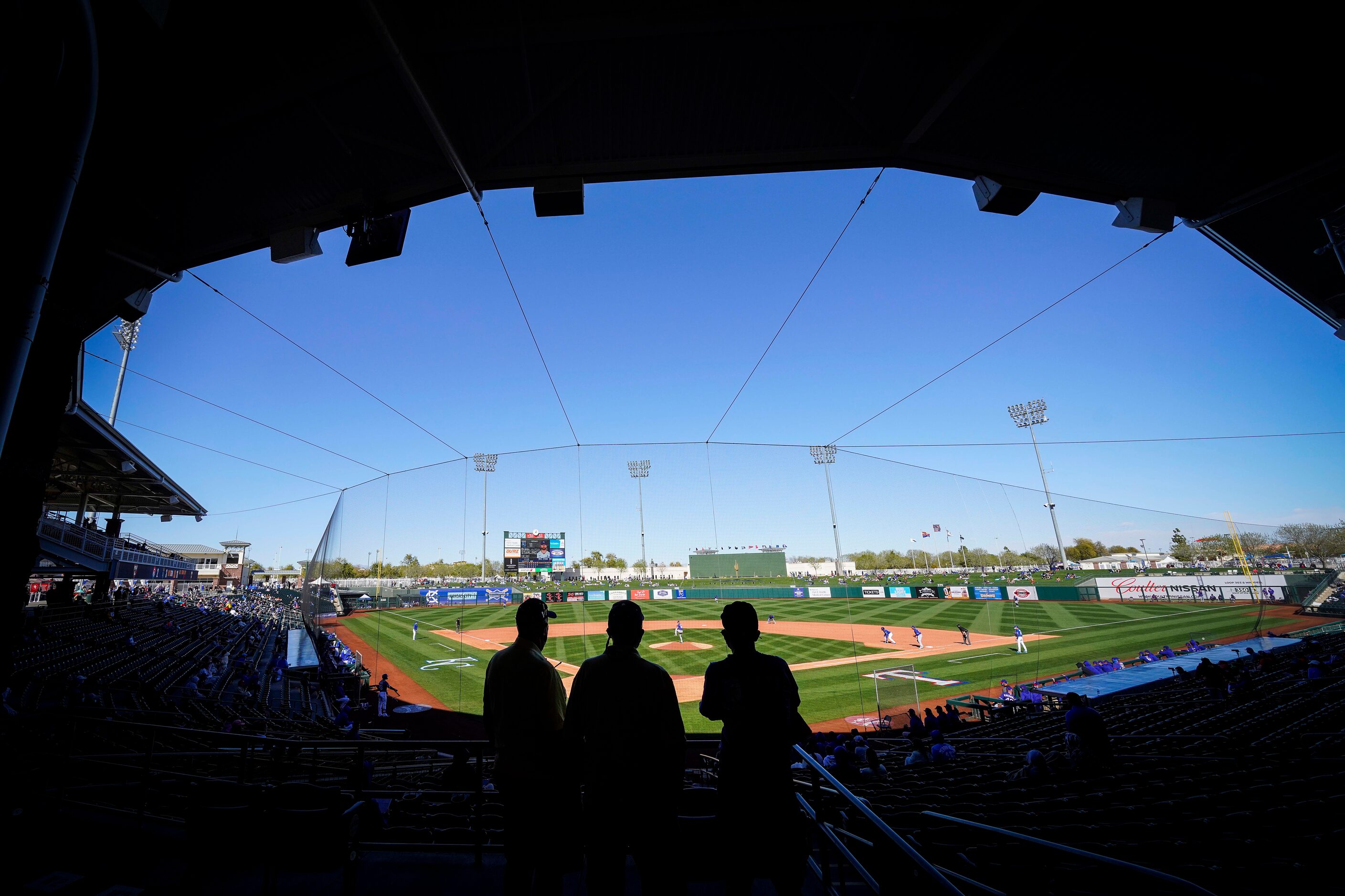 Fans watch from socially distant ‘pods’ during a spring training game between the Texas...