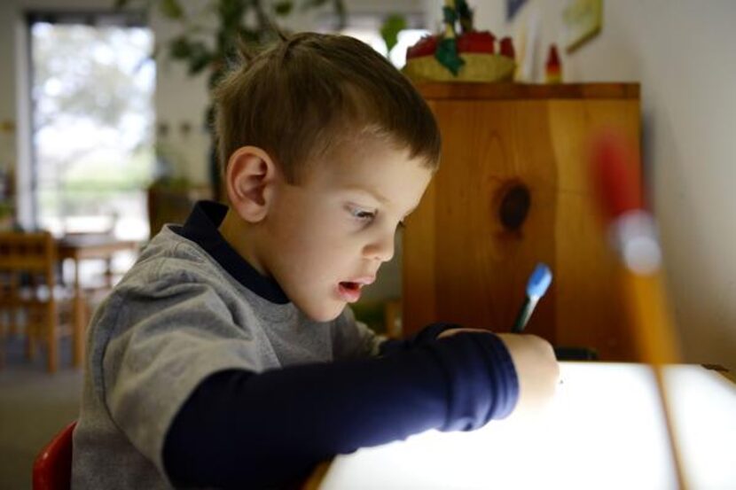 
Preschool student Zayne Wieland traces a flower for an assignment at The Dallas North...