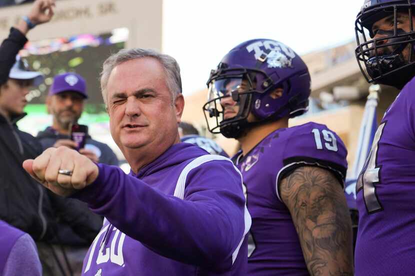 TCU head coach Sonny Dykes acknowledges fans as he waits with his players to take the field...