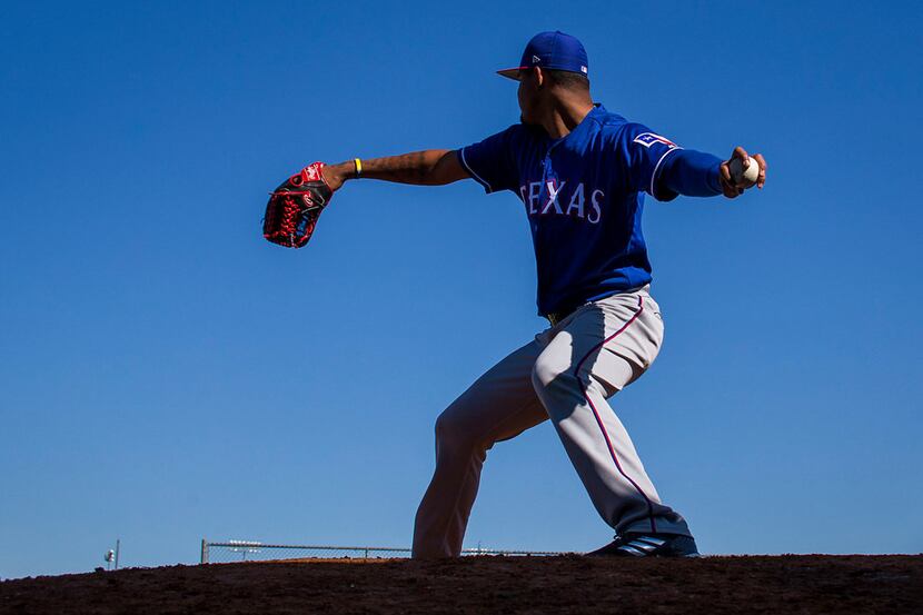 FILE - Texas Rangers pitcher Yohander Mendez throws in the bullpen during a spring training...
