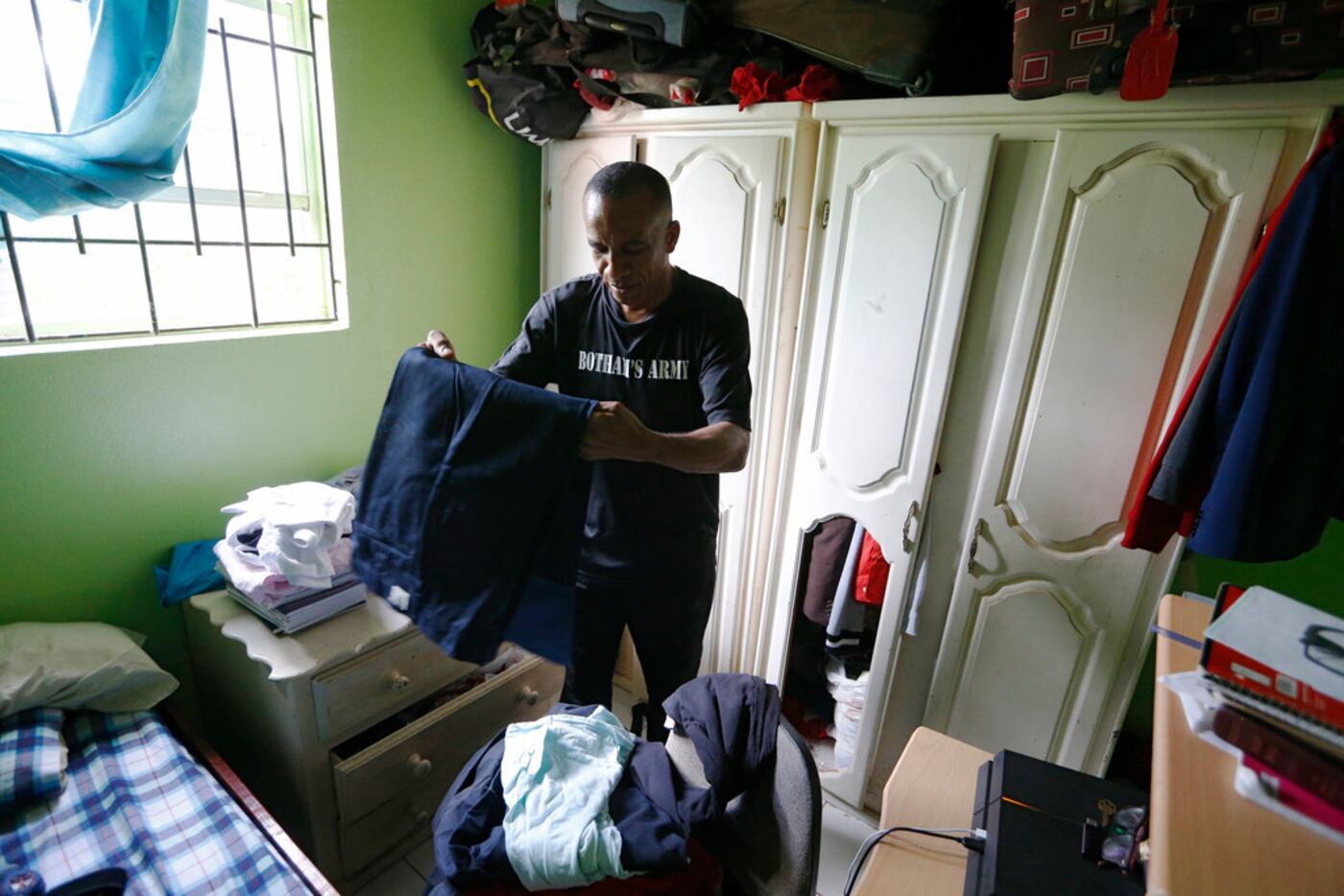 Bertrum Jean sorts through clothes that Botham Jean kept in the closet of his childhood...