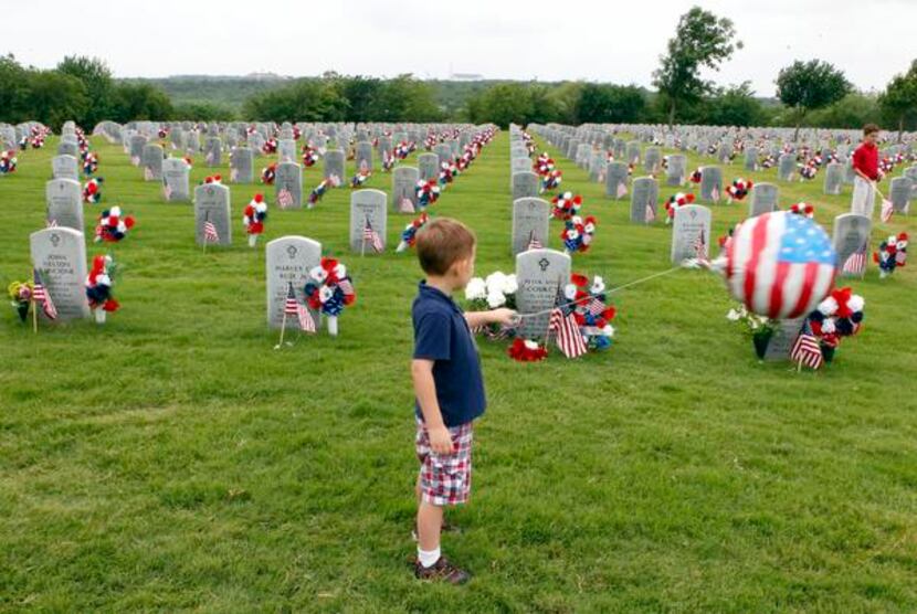 
Five-year-old Luke Bush looks at the grave of the brother he never knew during a ceremony...