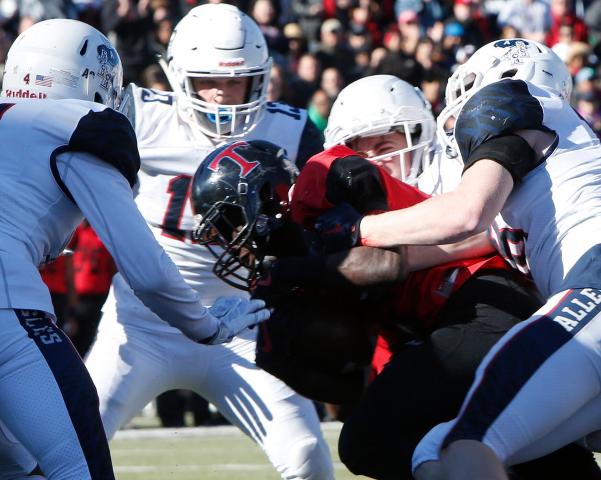 Euless Trinity running back Courage Keihn (21) powers his way past a group of Allen...