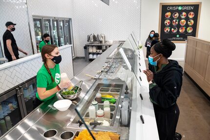 Server Greta Edmundson, left, completes a food order for Jasmine White, right, at the new...