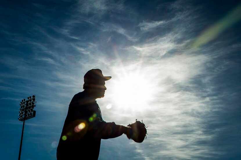 Country music singer Charley Pride plays catch during a spring training workout at the Texas...