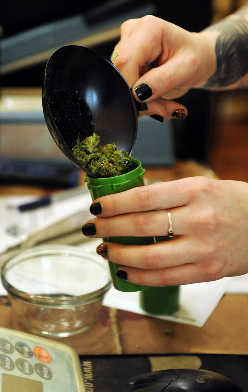 A bud tender fills a container with marijuana at the Northern Lights Cannabis Co. on Friday,...