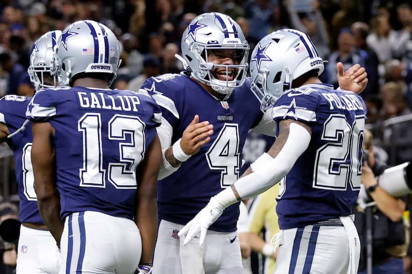 Dallas Cowboys quarterback Dak Prescott (4) congratulates running back Tony Pollard (20)...