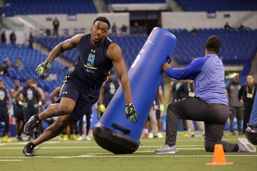 Michigan defensive end Taco Charlton runs a drill at the NFL football scouting combine in...