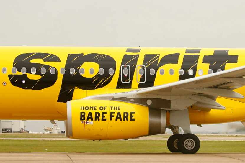 A Spirit Airlines passenger jet, with the 'Home of the Bare Fare' slogan on the jet engine...