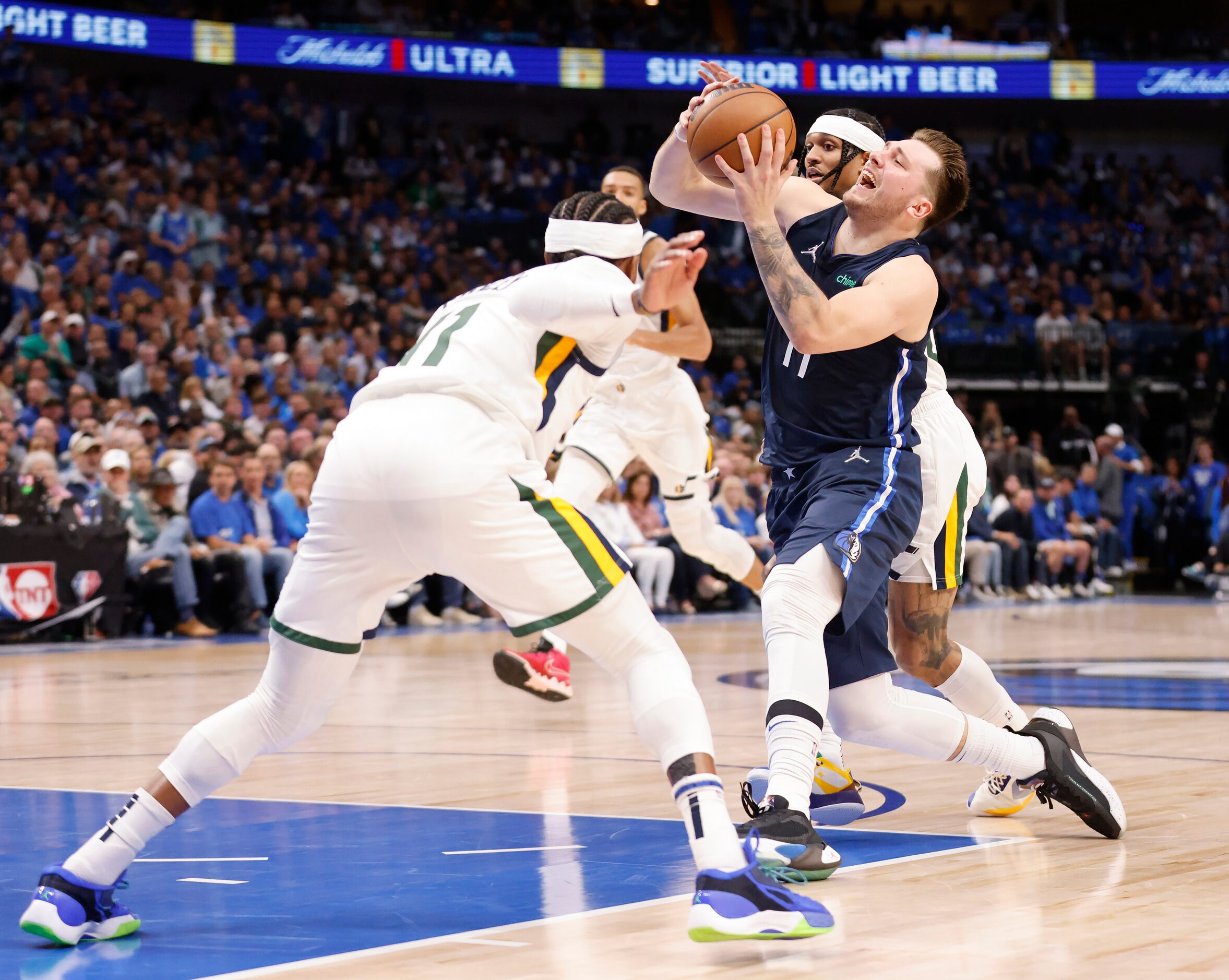 Dallas Mavericks guard Luka Doncic (77) drives to the basket between a pair of Utah Jazz...