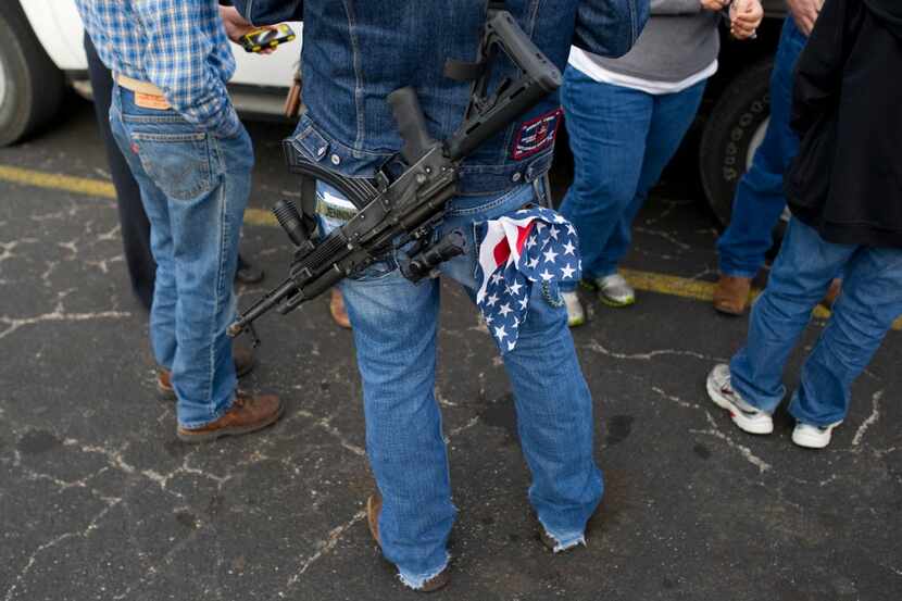 Johnny Shaver carries his rifle and American flag bandana during an open carry long rifle...