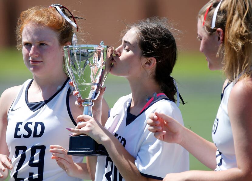 ESDs Gianna Pope (30) kisses the state championship trophy between teammates Story Langston...
