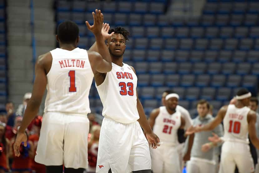 SMU's Semi Ojeleye (33) high-fives teammate Shake Milton, left, during the first half of an...