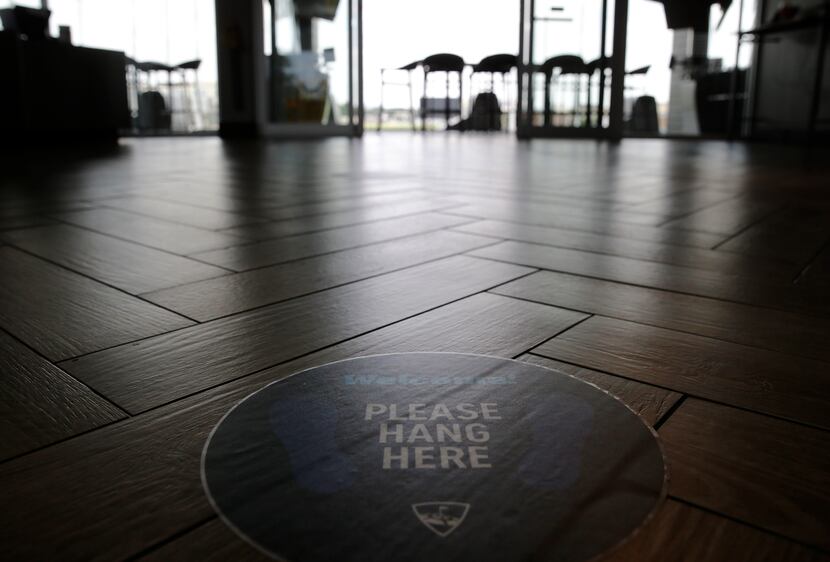 A sign is displayed encouraging social distancing at Topgolf in The Colony, on Friday, May...