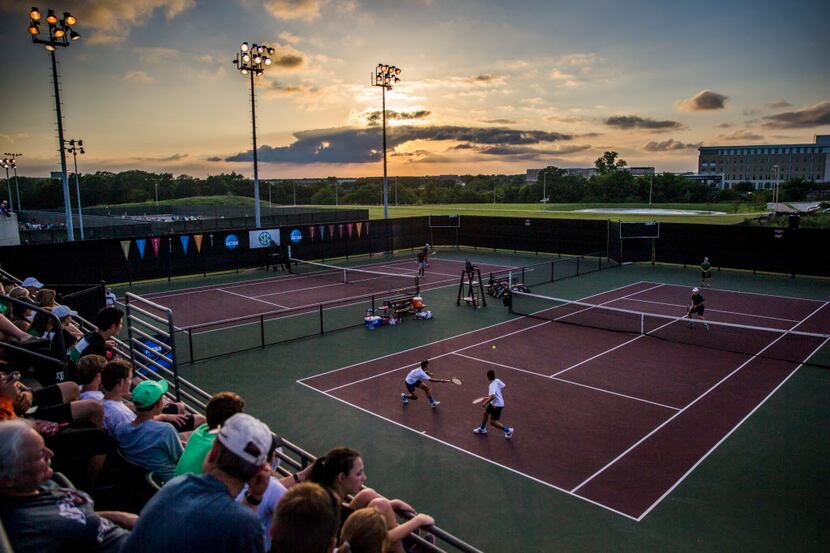 High School tennis players continue play at sunset after a four hour rain delay at the UIL...