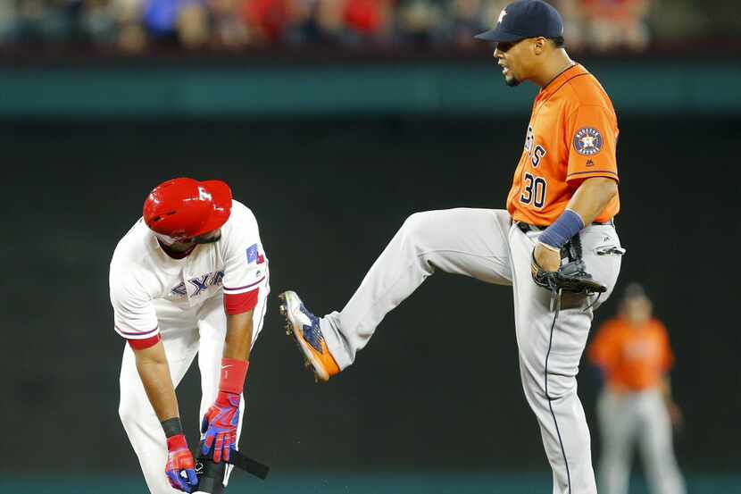 Texas Rangers batter Elvis Andrus (1) is kicked in the butt by Houston Astros center fielder...
