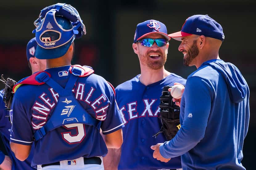 Texas Rangers infielder Logan Forsythe laughs with manager Chris Woodward and catcher Isiah...