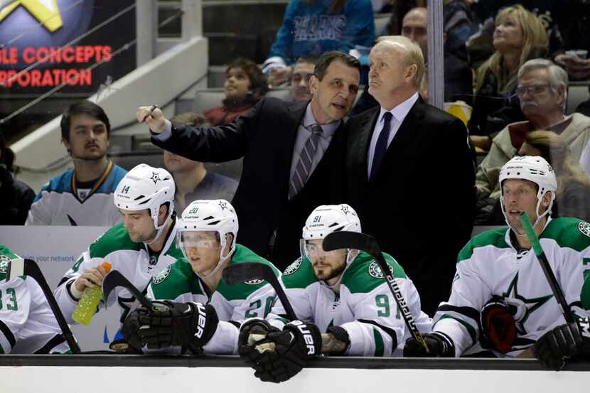 Dallas Stars head coach Lindy Ruff, center right, talks to one of his assistants during an...