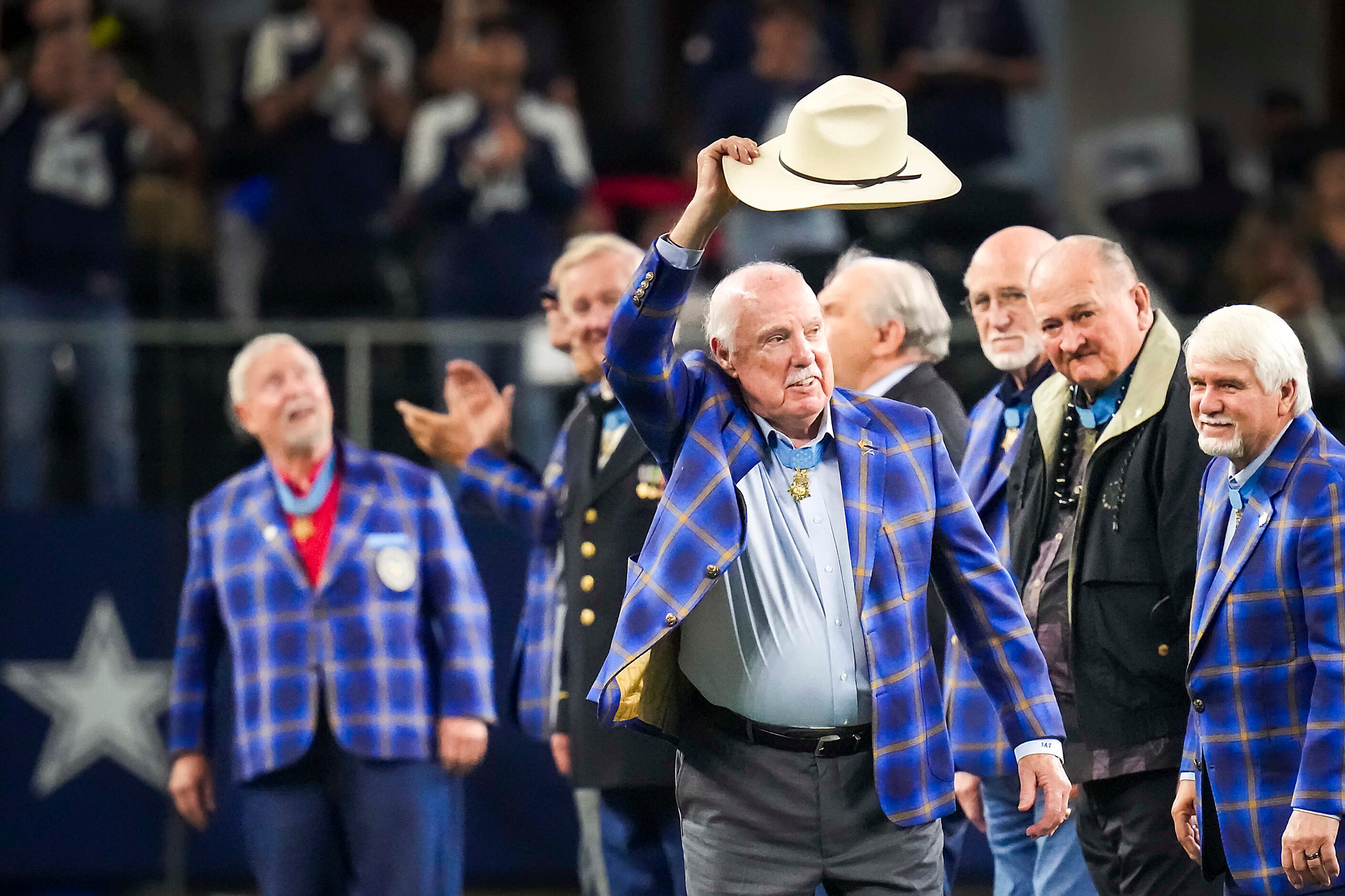 Medal of Honor recipient Jim Taylor tips his hat to the crowd as he is recognized with...