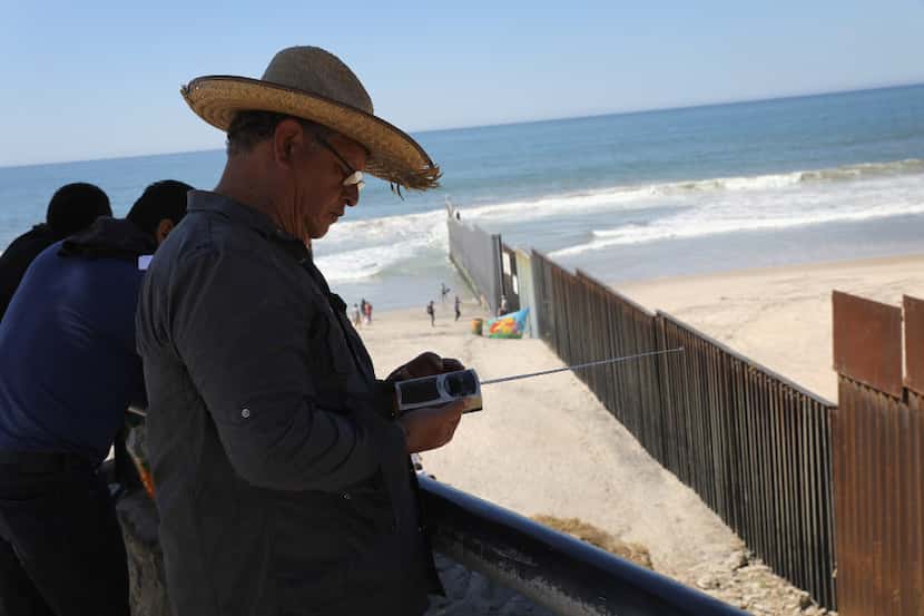 A man listens to a U.S. radio station while on the Mexican side of the U.S.-Mexico border...