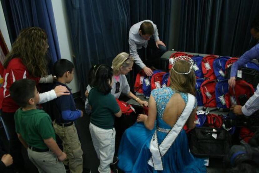 
Students line up to receive free backpacks. Items in the packs included composition...