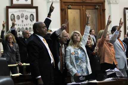 State Senator Wendy Davis, center, celebrates with colleagues as bedlam breaks out near...