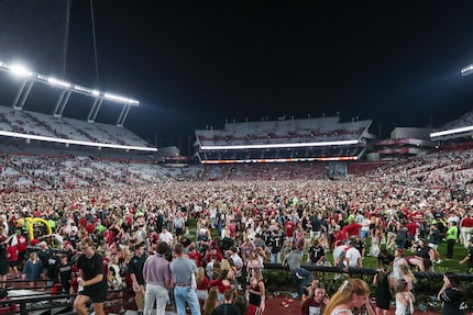 South Carolina fans storm the field after an NCAA college football game against Texas A&M,...