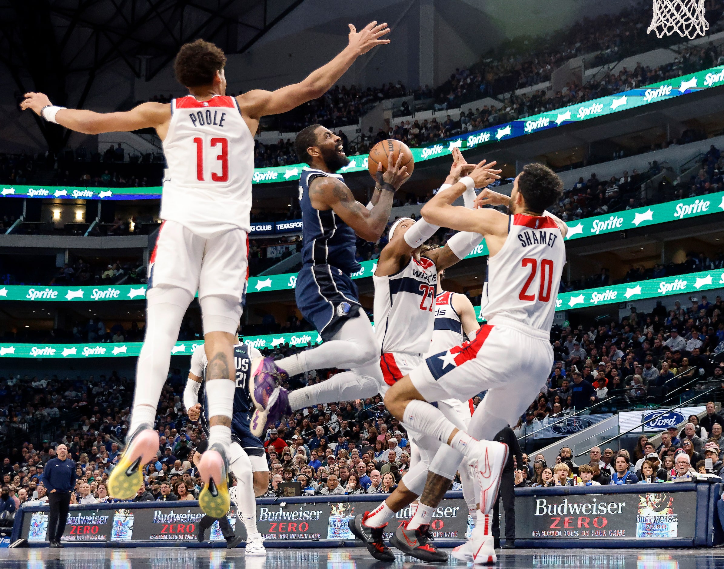 Dallas Mavericks guard Kyrie Irving (11) is surrounded by Washington Wizards players as he...