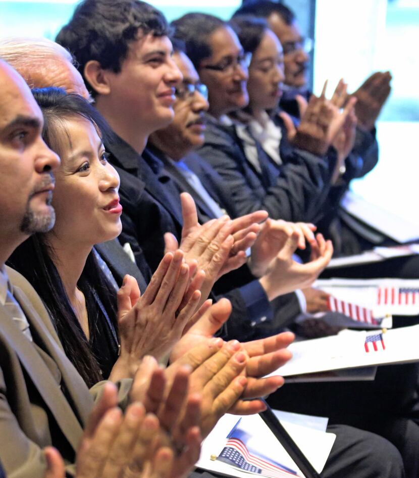 New U.S. citizens applaud during a naturalization ceremony at the Amon Carter Museum of...