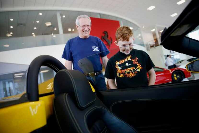 
Ryan Holman, 9, of Plano, Texas, looks inside a 2008 Ferrari F430 while visiting the...