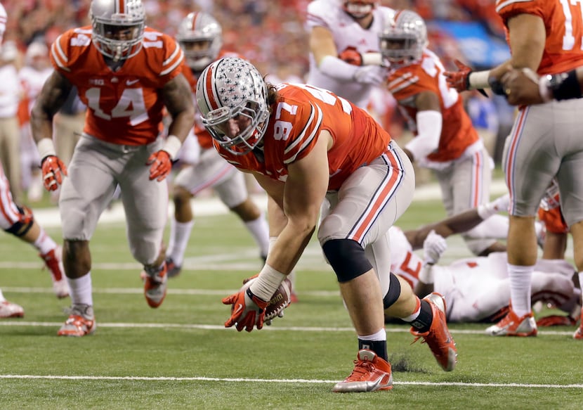 Ohio State defensive lineman Joey Bosa (97) recovers a fumble before running it back for a...