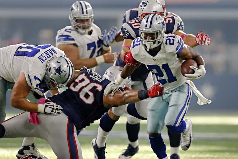 Dallas Cowboys running back Joseph Randle (21) fights off New England Patriots defensive...