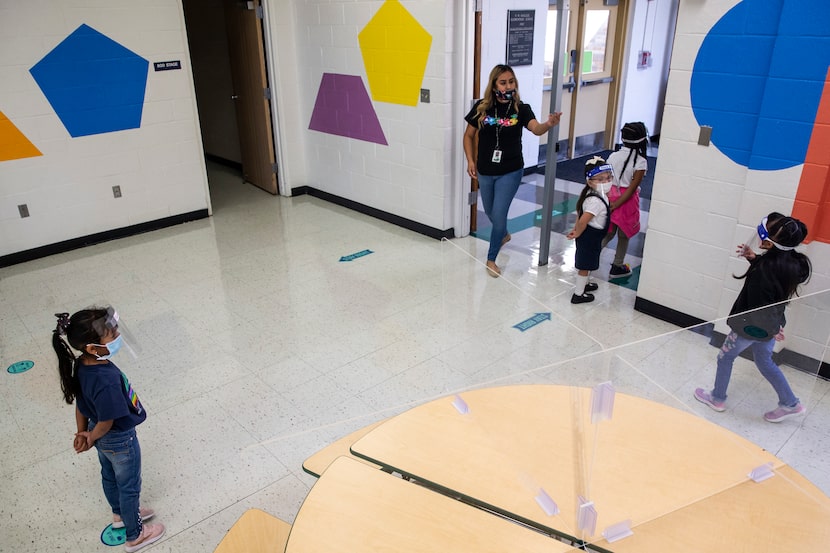 Pre-K 4 student Karen Martinez-Calderon (left) waits her turn as Pre-K teacher Nicole...