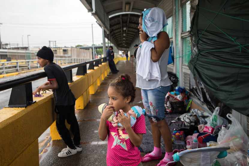 Elsy Hernandez and her children Genesis, 5, and David, 9, immigrants from Honduras, wait on...