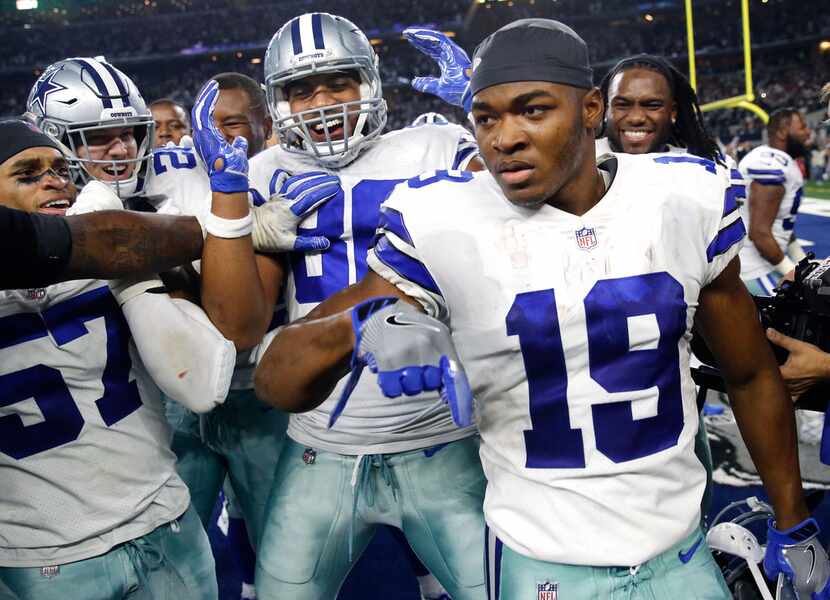 Dallas Cowboys wide receiver Amari Cooper (19) is congratulated by teammates after scoring...