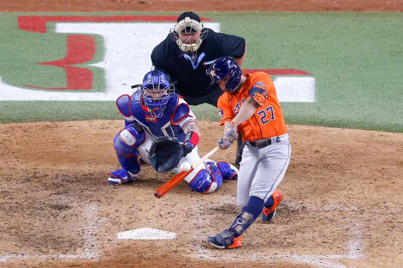 Houston Astros second baseman Jose Altuve (27) hits a three-run, go-ahead home run off of...