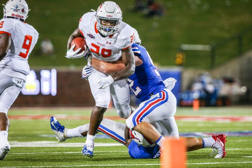 Houston Baptist running back Dreshawn Minnieweather (28) is tackled by Southern Methodist...