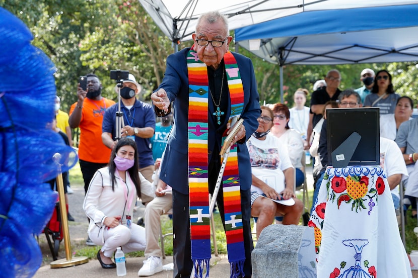 Rev. Isabel Gomez blessed Santos Rodriguez's grave of with water during Saturday's service.