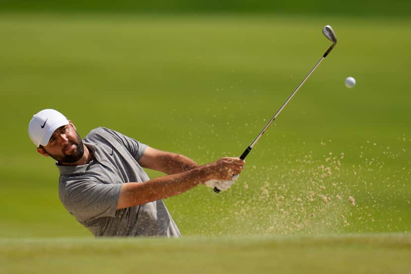 Scottie Scheffler hits from the bunker on the seventh hole during the third round of the PGA...