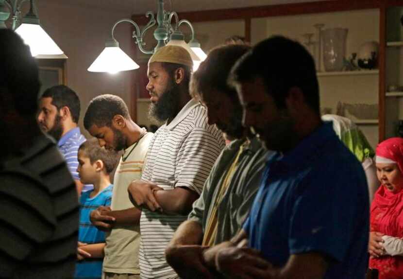 
Daniel Abebe (center) joins other Muslims in prayer before a nightly iftar dinner at...