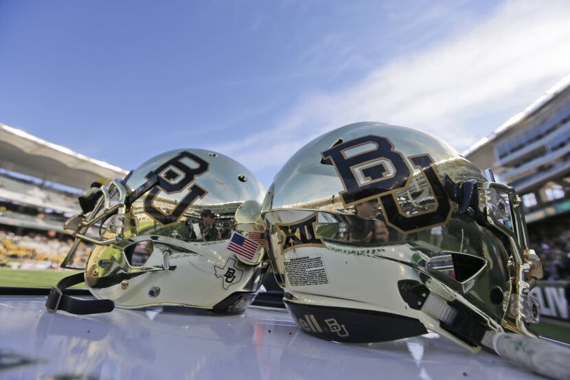 In this file photo, Baylor helmets on shown the field after an NCAA college football game in...